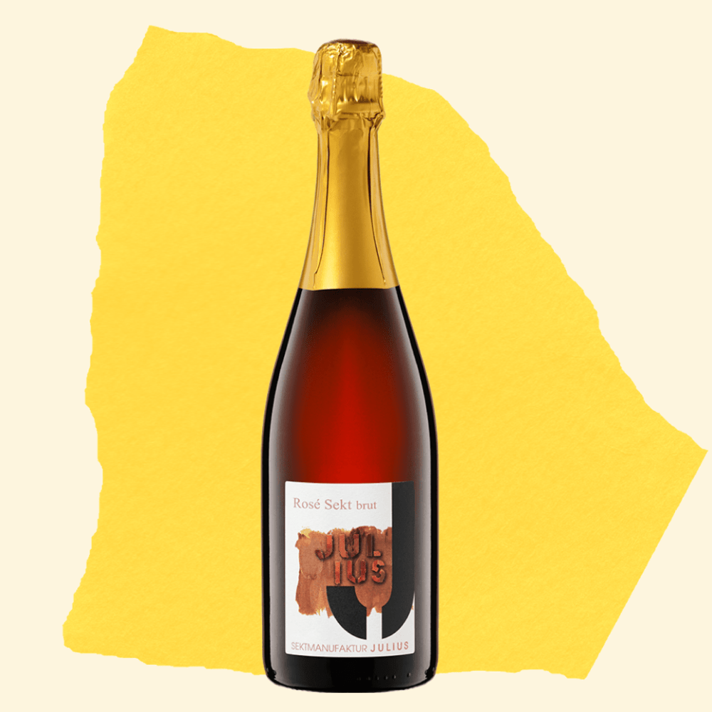Flasche Julius Rosé Sekt brut auf gelbem Hintergrund – erhältlich bei be°bubbly