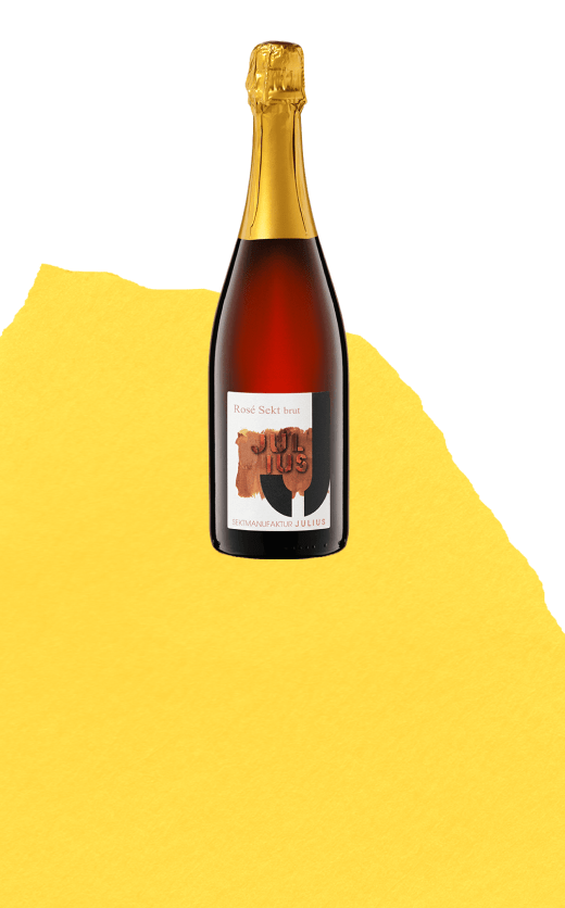 Flasche Julius Rosé Sekt brut auf gelbem Hintergrund – erhältlich bei be°bubbly